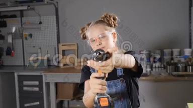 10岁的木木工女的画像，手持电子钻，对着镜头摆姿势。 <strong>小小</strong>的建筑理念。 <strong>高清高清</strong>